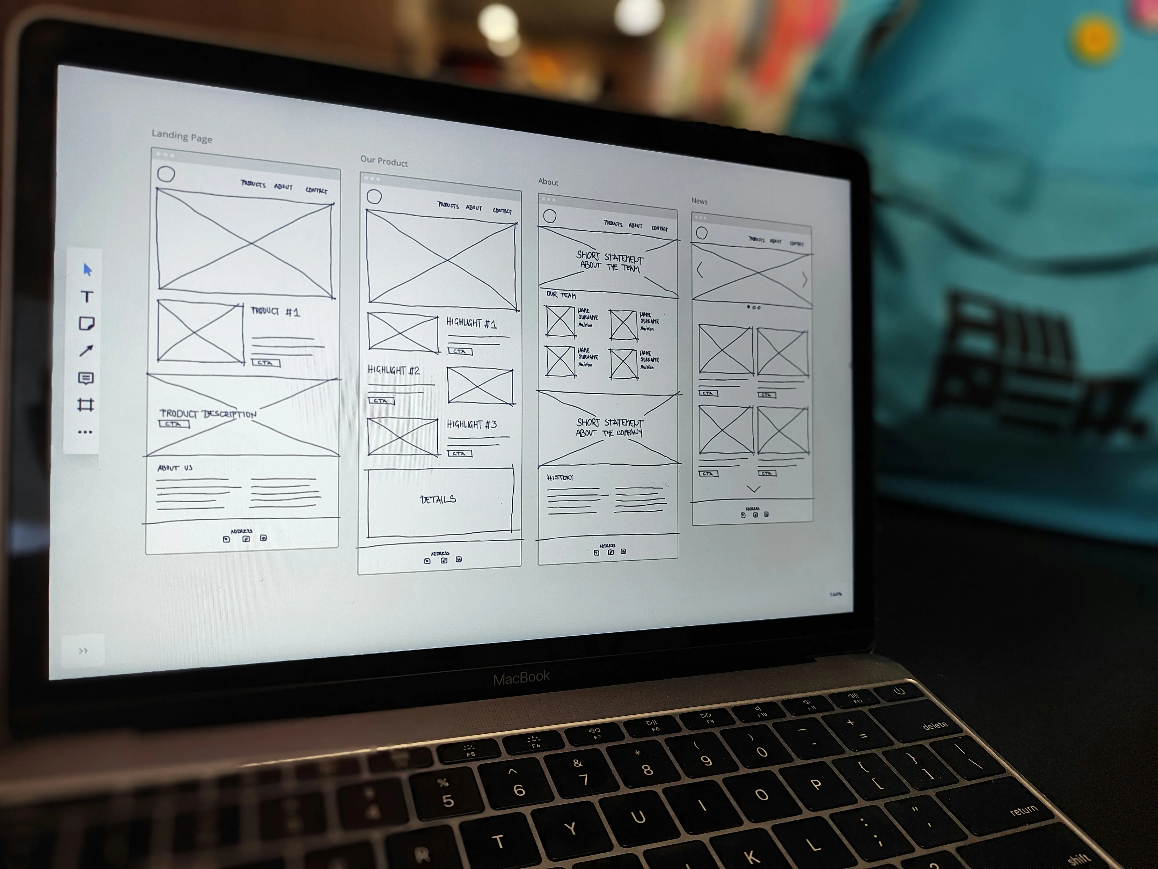 Hand-sketched website wireframes on a laptop screen.